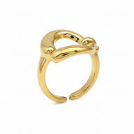 Anello scultoreo in acciaio oro lucido con design a nodo astratto e linee fluide.