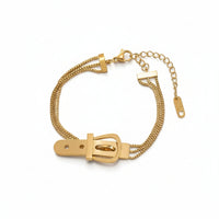 Bracciale sofisticato a tre fili con dettaglio fibbia. In acciaio inossidabile oro, perfetto per completare un outfit elegante.