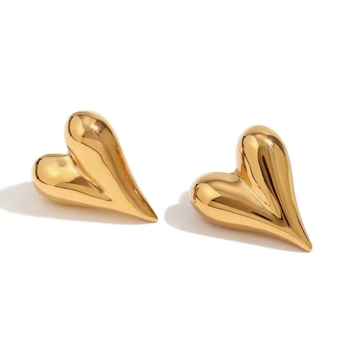Paio di orecchini a forma di cuore bombato in acciaio inossidabile color oro su sfondo bianco