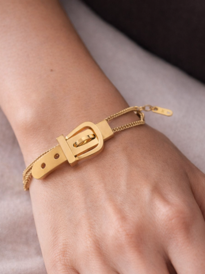 Bracciale dorato a tre catenine con dettaglio a fibbia indossato al polso