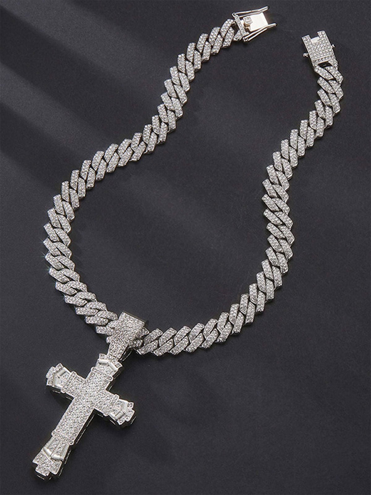 Collana a maglia cubana argento con croce interamente ricoperta di pietre brillanti, su sfondo scuro