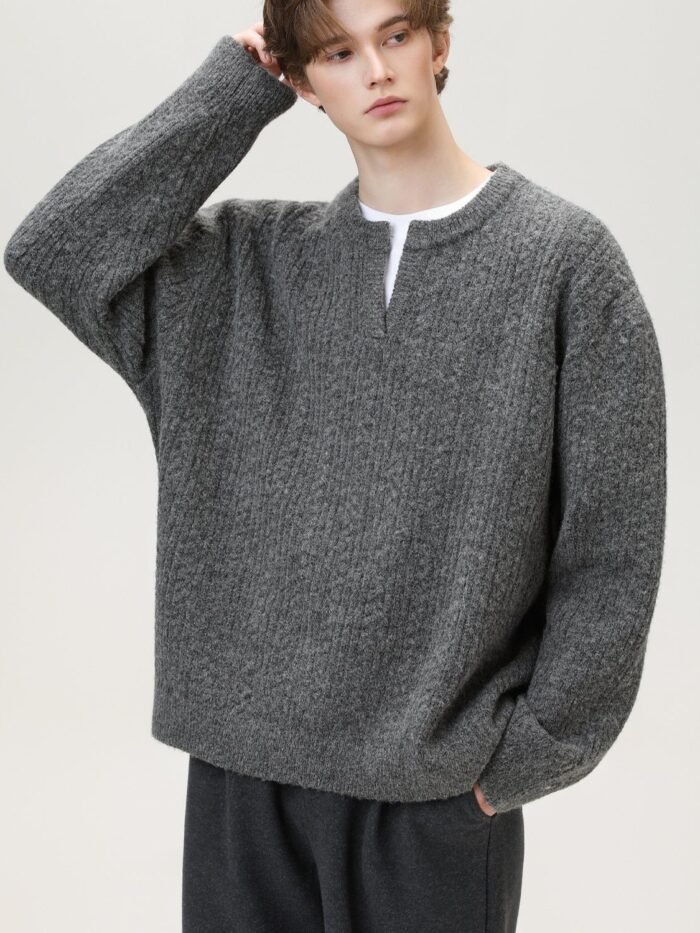 Maglione knit grigio con scollo a spacco indossato su t-shirt bianca, vestibilità con spalle scese