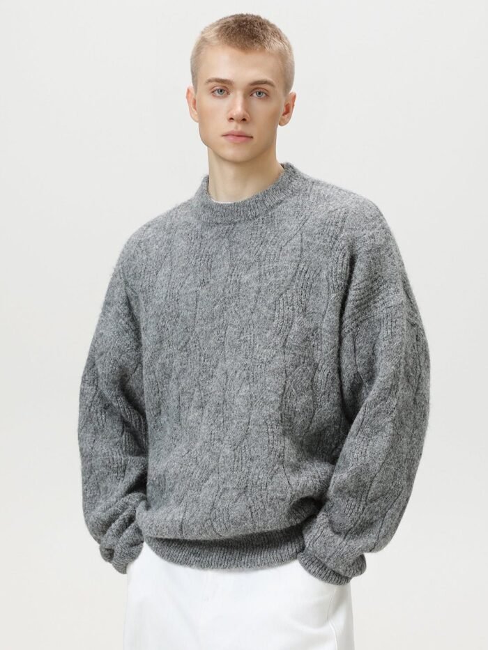 Maglione oversized cable knit grigio girocollo con trecce ondulate indossato con pantaloni bianchi