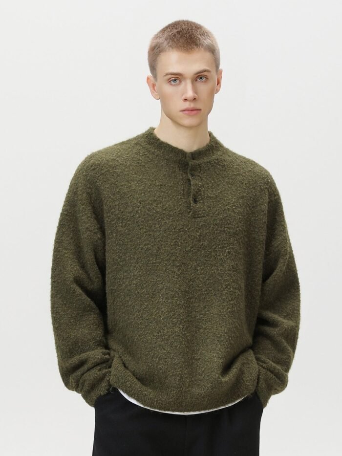 Maglione polo oversized verde oliva con scollo Henley a bottoni indossato da un modello