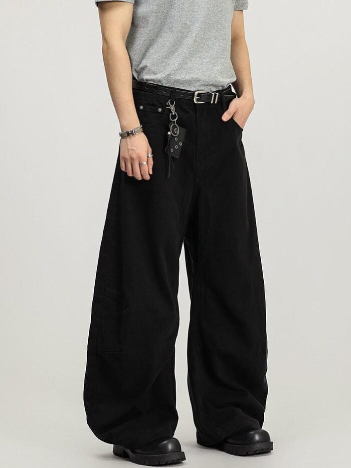 Pantaloni wide-leg neri in cotone visti di tre quarti, con cintura in pelle e fibbia in metallo