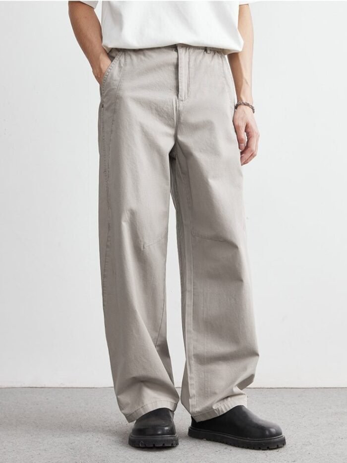 Pantaloni effetto jeans grigio chiaro con gamba dritta ampia, indossati con t-shirt bianca e scarpe nere
