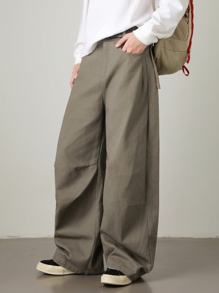 Pantaloni utility a gamba larga color oliva indossati con maglia bianca e sneakers, vista frontale