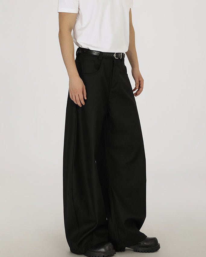 Pantaloni wide-leg neri dalla gamba ampia e arrotondata visti di tre quarti, con t-shirt bianca
